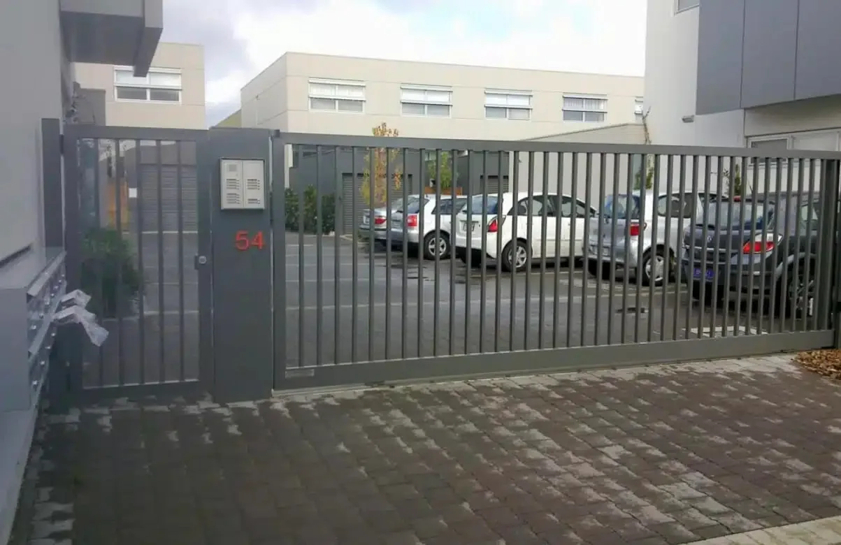 Black automatic sliding gate across an apartment car park entrance