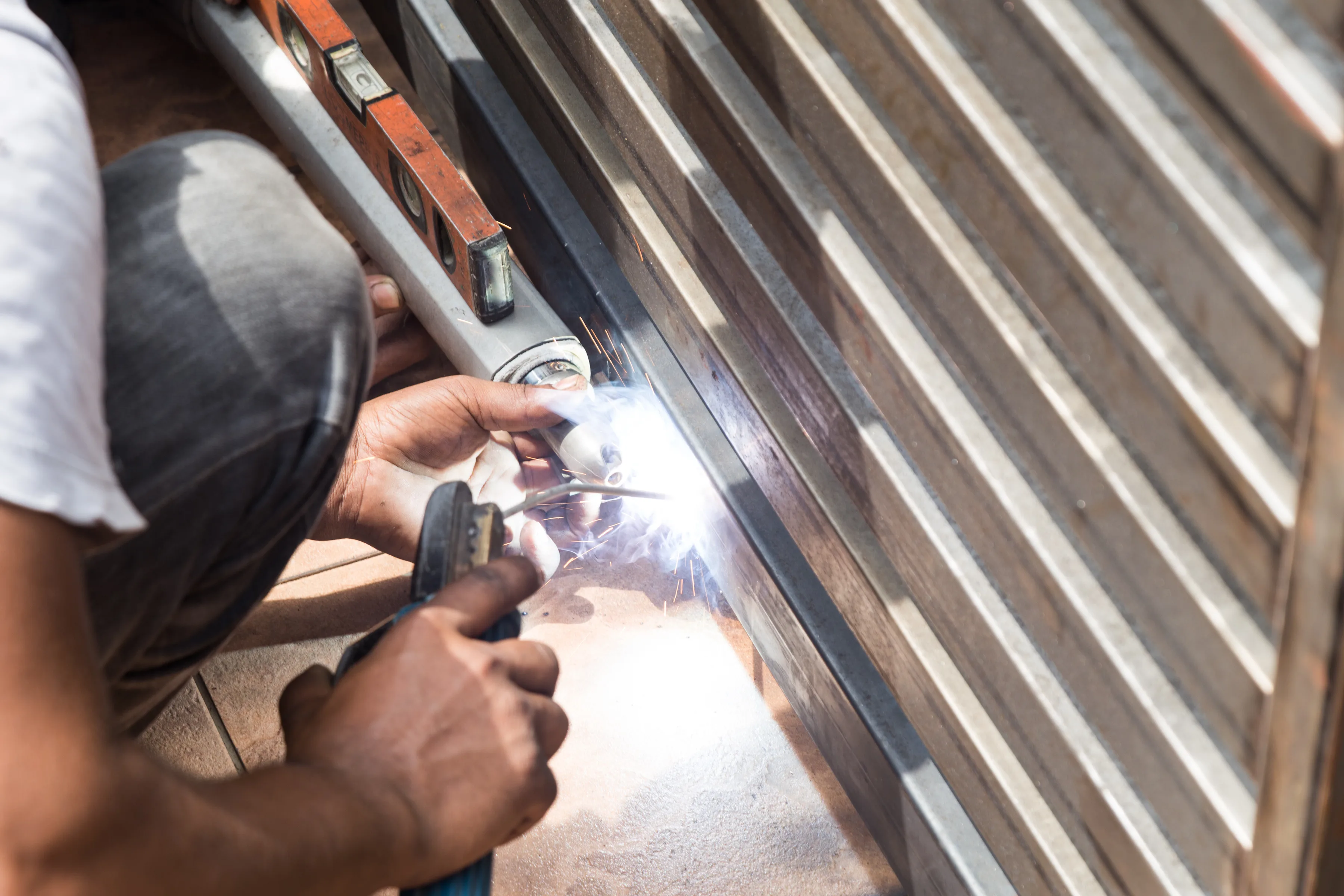Technician welding and repairing a metal gate