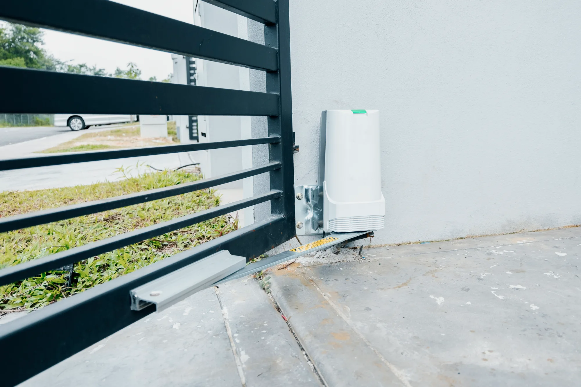 Electric gate motor installed beside a sliding gate